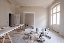 A room under renovation with tools and materials scattered across the floor