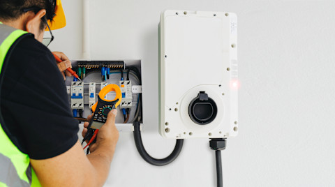 A man is installing a new home EV charger