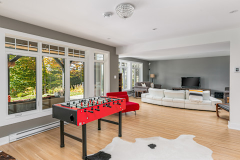 A man cave with a football table, tv, and sofa