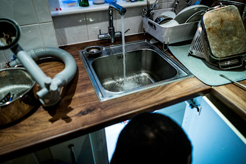 A plumber fixing a slow draining sink