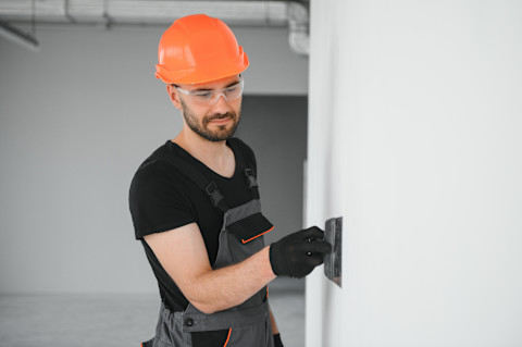 A tradesperson is repairing plasterboard