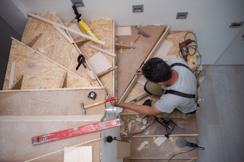 A carepenter carving wood to make staircase.