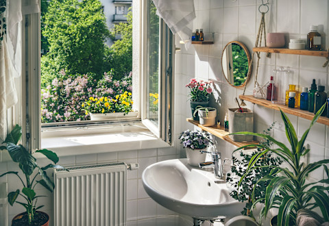 An open window in a modern eco-friendly bathroom brings in natural light and adds a touch of greenery for a fresh, inviting look.