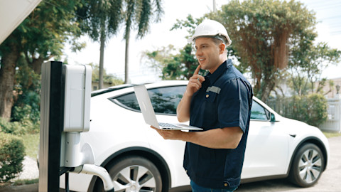 An EV technician is installing on-street charging for a customer.