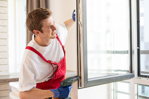 A man is checking a repaired double glazed window.