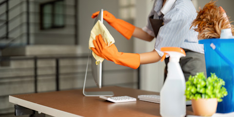 Woman clean in office room at office. Housekeeper or maid cleaner feel happy wipe mop and clean the work desk.