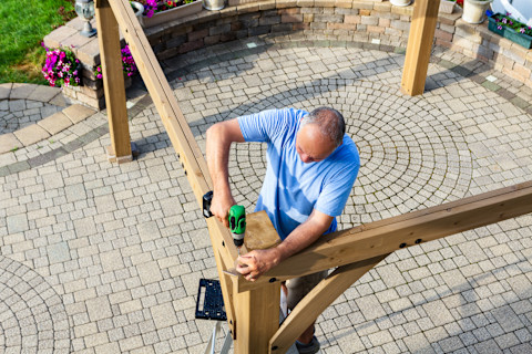 A man is constructing a new gazebo.
