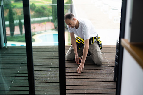 A man is constructing a porch extension