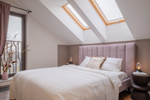 The image shows a cozy bedroom with a soft, neutral color palette.