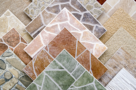 This image shows a close-up view of colourful ceramic tile samples displayed in a shop, showcasing a variety of textures and patterns.