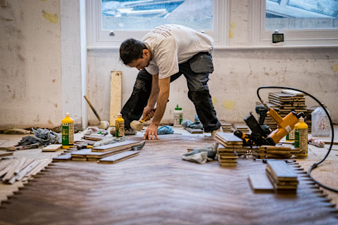 A floor fitter fixing a resin flooring.