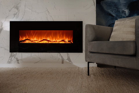 This image shows a view of a modern electric fireplace with a sleek black frame and realistic flame effects. The fireplace is set against a minimalist interior, adding warmth and ambience to the contemporary living space.