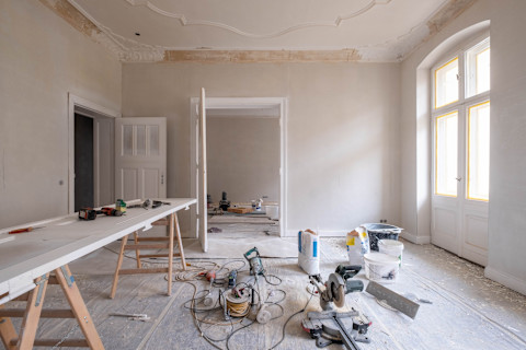 A room full of tools, supplies and a white workbench.