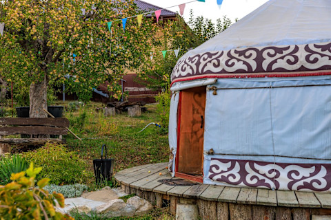A colourful yurt in a green garden.