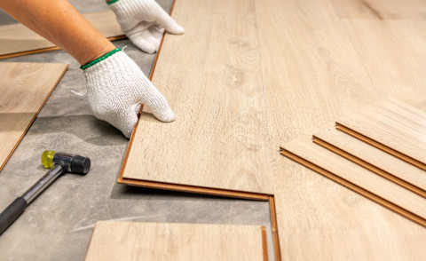 Worker Installing Interlocking laminate floor.
