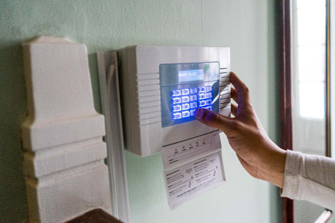 Someone is creating a setting on a burglar alarm.
