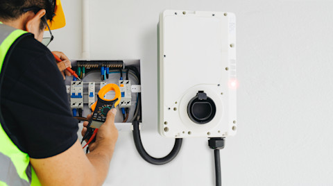 A man is installing a new home EV charger
