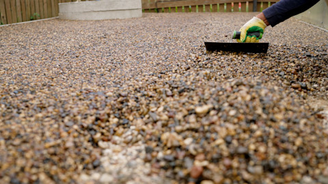 A tradesperson is laying a new resin driveway