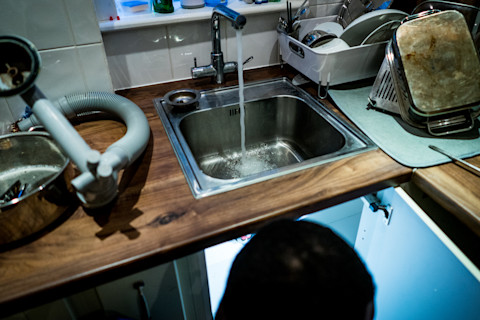A plumber fixing a slow draining sink