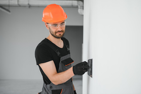 A tradesperson is repairing plasterboard