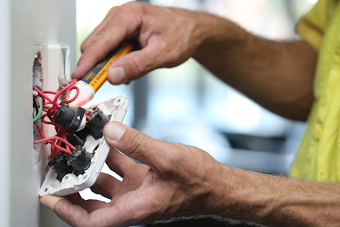 A technician is replacing a light switch.