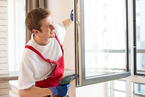 A man is checking a repaired double glazed window.