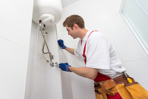 A tradesperson is installing a new boiler in a home.