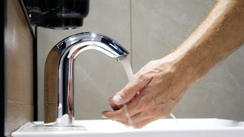 Person holding hands under running water