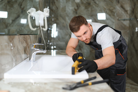 A tradesperson is renovating a bathroom
