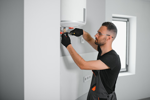 A tradesperson repairing a new boiler.