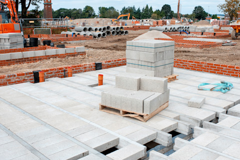 This image shows the installation process of block and beam flooring in the foundations of a residential building that is being constructed.