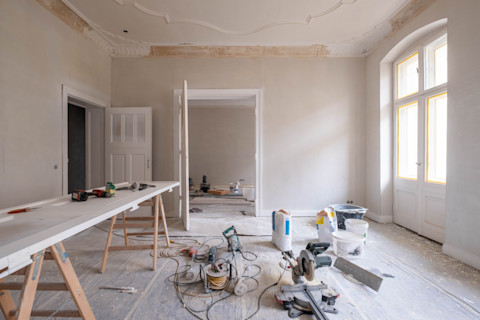 A room full of tools, supplies and a white workbench.