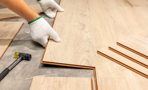 Worker Installing Interlocking laminate floor.
