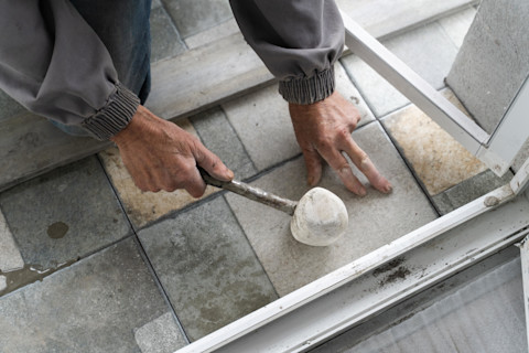man-laying-tile-with-mallet