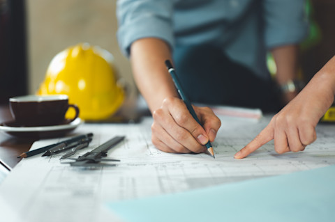Two structural engineers are discussing some plans for a new house build.