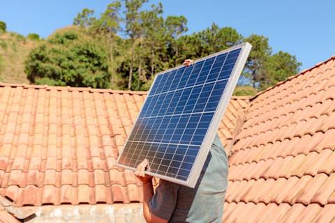 Technician carrying solar panel