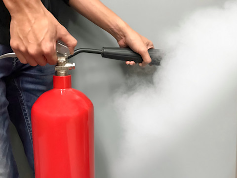 Person using a fire extinguisher