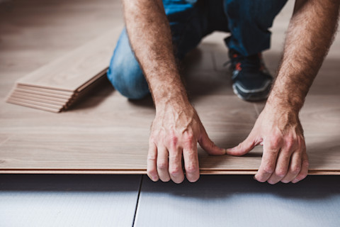 Man is installing a floating wood floor.