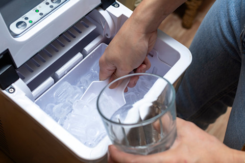 A modern ice maker machine on a countertop, showing its sleek design and control panel.