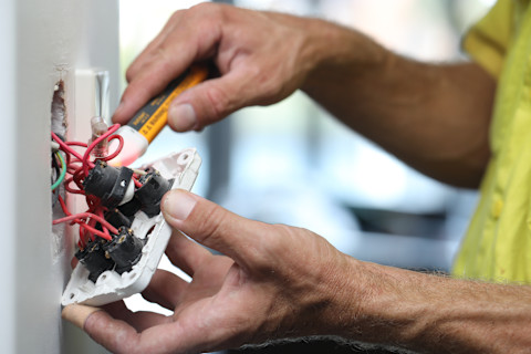 A technician is replacing a light switch.