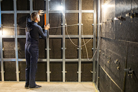 A person from insulation company soundproofing a room.