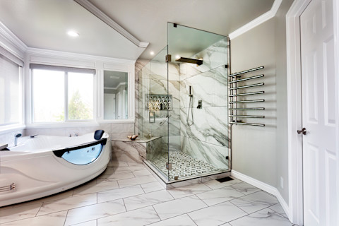 Spacious modern contemporary master bathroom with jacuzzi hot tube and large glass walk in shower.