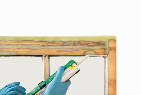 A tradesperson is repairing dry rot on wood.