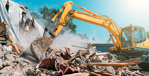 A building is being demolished with a machine.