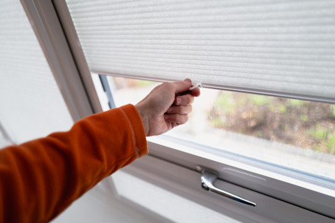 A man is testing new conservatory window blinds.