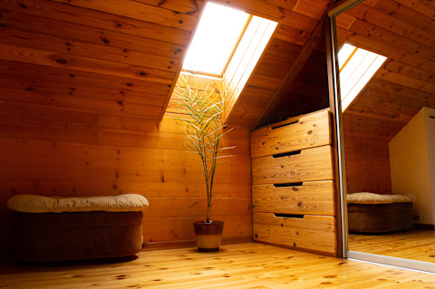 Cosy wooden loft bedroom with skylight lighting