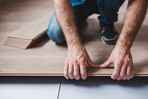 Man is installing a floating wood floor.