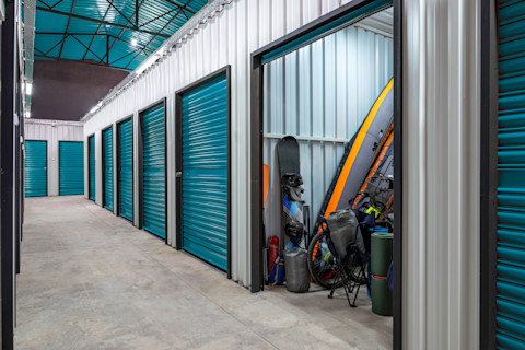 This image shows an open storage unit filled with sports equipment. Other storage units are in view but they are closed.