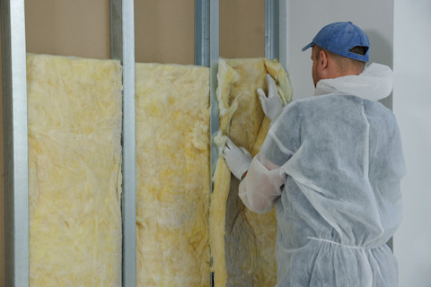 A man is adding insulation to a conservatory