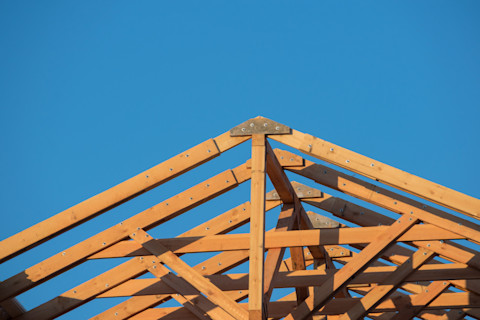 This image shows a close up of roof trusses as a house is being built